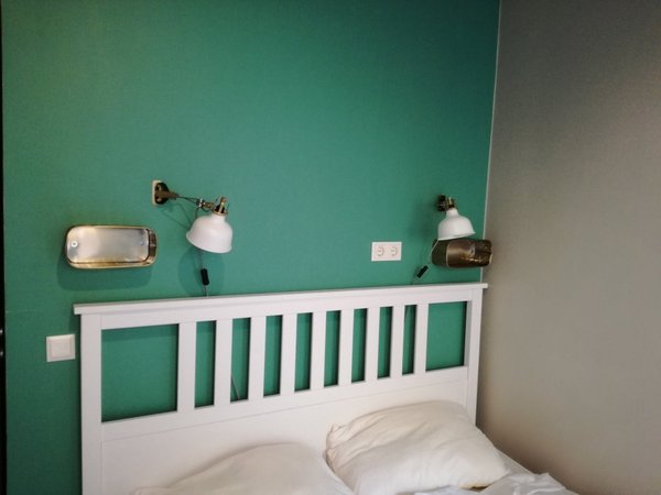 Modern and cozy double room with stylish green walls and chic lighting at Munich Hauptbahnhof accommodation